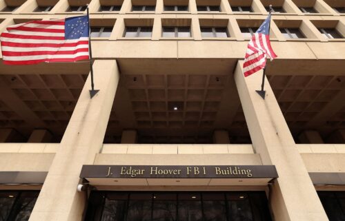 Flags fly over an entrance to FBI headquarters.