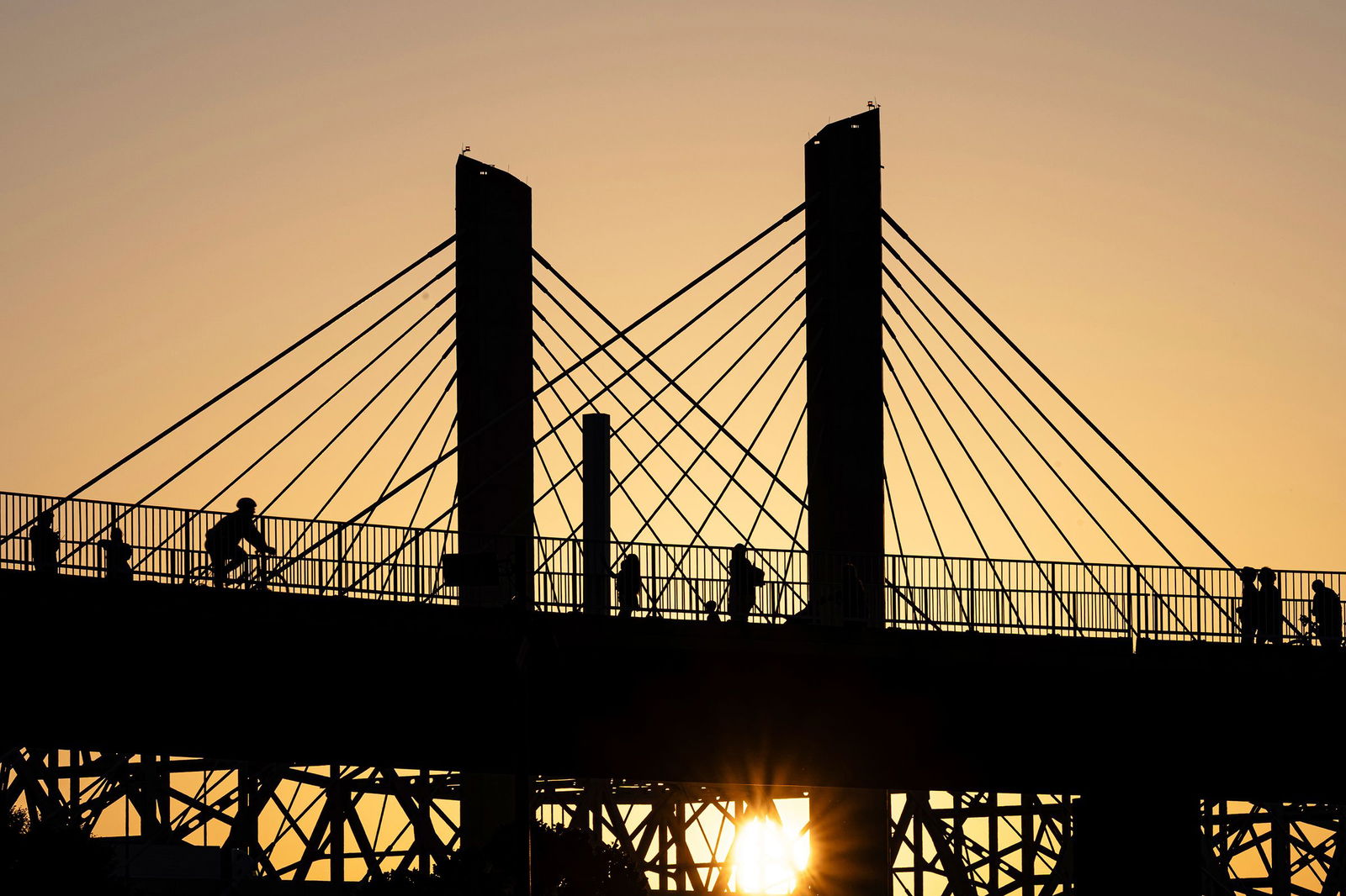 <i>Jon Cherry/AP via CNN Newsource</i><br/>Poeple walk across the Big Four Bridge as the sun sets at Waterfront Park on June 22 in Louisville