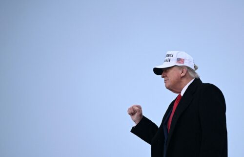 President Donald Trump raises a fist as he steps off of Air Force One upon arrival at Calgary International Airport