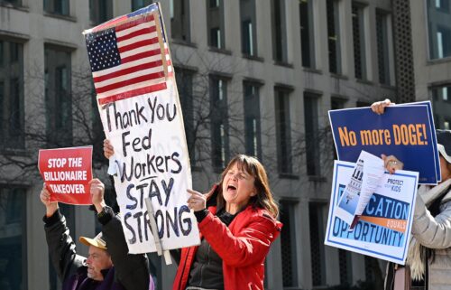 Protesters hold signs in solidarity with the American Federation of Government Employees of District 14 at a rally in support of federal workers at the Office of Personnel Management in Washington
