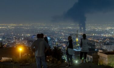 Iranian people gather at the scene of an explosion at a residential complex due to Israeli attacks in Tehran