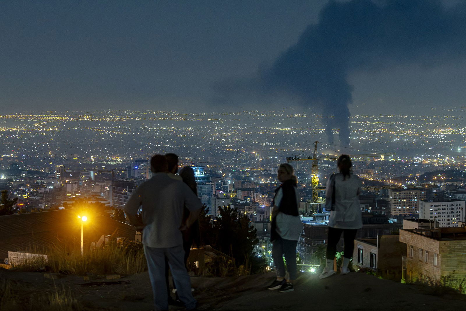 <i>Morteza Nikoubazl/NurPhoto/Getty Images via CNN Newsource</i><br/>Iranian people gather at the scene of an explosion at a residential complex due to Israeli attacks in Tehran