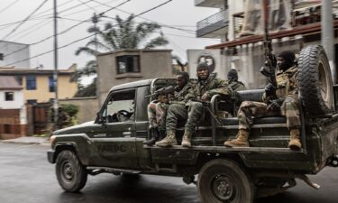 Congolese families displaced by ongoing clashes in eastern Democratic Republic of Congo line up as they wait for Rwandan police and immigration officials to allow them to return to the country