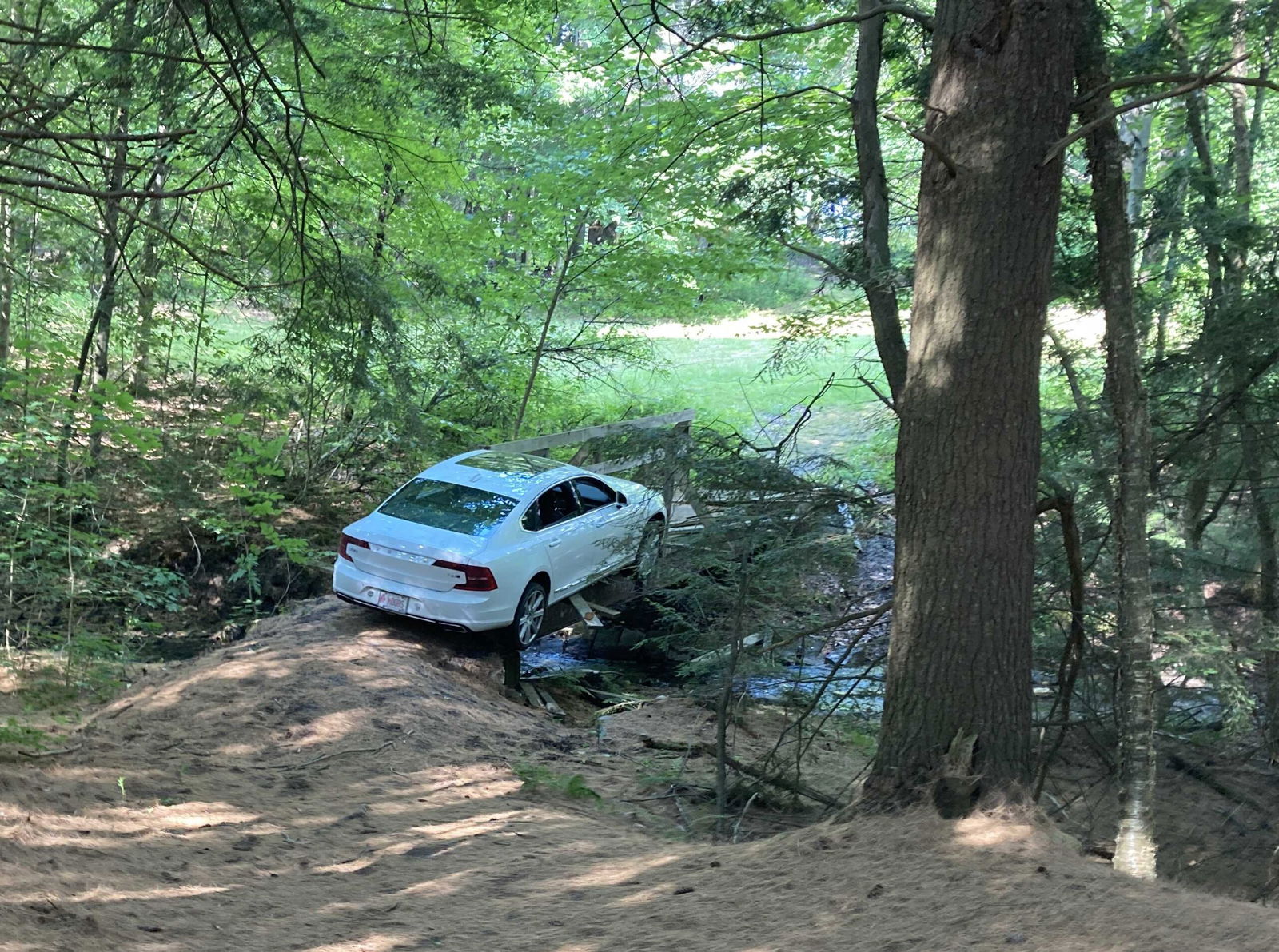 <i>WPTZ via CNN Newsource</i><br/>Christopher Shorey's Volvo got stuck on the narrow pedestrian bridge and broke through the wooden structure. His car wound up partially hanging off the bridge