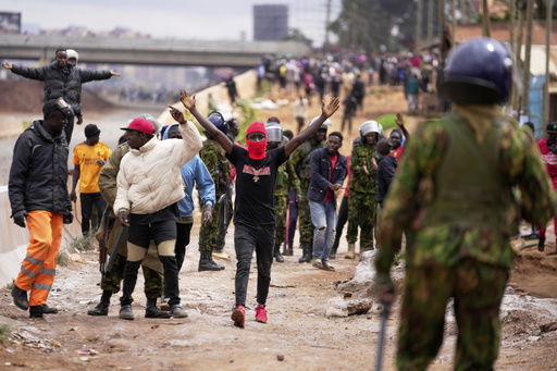 ADDITION: CLARIFIES DATE - Demonstrators gesture to anti-riot police during demonstrations to mark the historic 1990 Saba Saba (a Swahili word that means seven seven) protests for democratic reforms in the Kangemi slum of Nairobi
