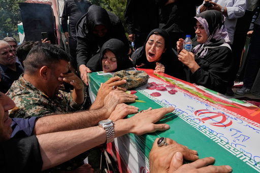Relatives mourn over the flag-draped coffin of Mahan Setareh