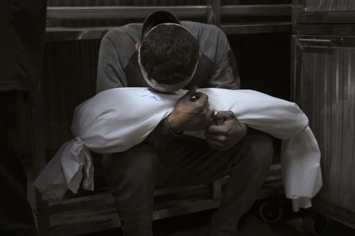 Hossam Azzam holds the body of his child