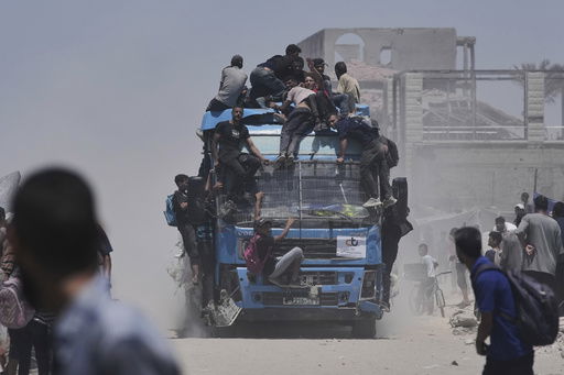 Palestinians hold onto an aid truck returning to Gaza City from the northern Gaza Strip on Tuesday