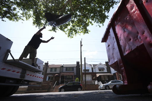 A man tosses trash at a garbage collection site