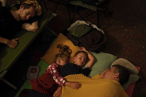 A family sleep on the platform of a metro station as they take cover during a Russian attack on Kyiv