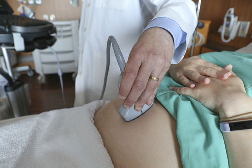 FILE - A doctor performs an ultrasound scan on a pregnant woman at a hospital in Chicago