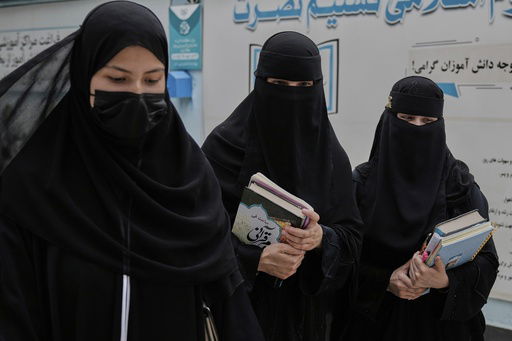 Afghan girls walk through the courtyard of a religious education center in Kabul