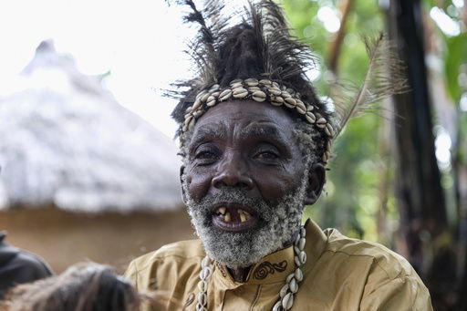 Seer Atukung Tafala speaks during an interview with The Associated Press outside his igloo-like shrine in Kampala