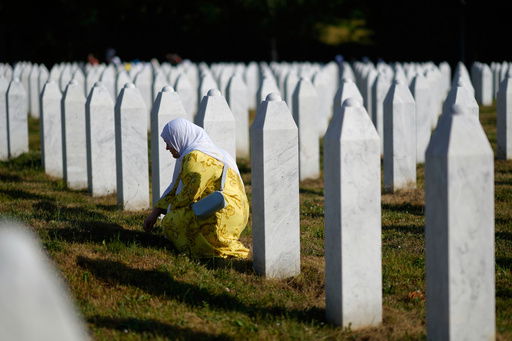 A woman mourns next to the grave of her relative