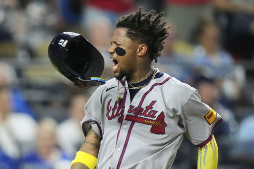 Atlanta Braves' Ronald Acuna Jr. celebrates after scoring on a three-run double hit by Austin Riley during the eighth inning of a baseball game against the Kansas City Royals