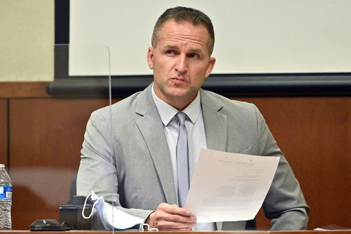 FILE - Former Louisville Police officer Brett Hankison examines a document as he answers questions from the prosecution