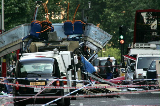 FILE - The wreckage of a double-decker bus with its top blown off by a bomb and damaged cars scattered on the road at Tavistock Square in central London