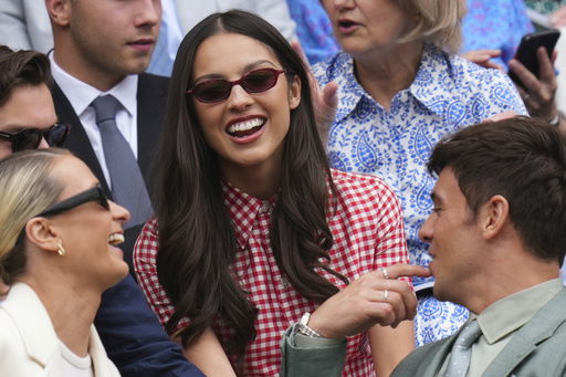 Singer Olivia Rodrigo smiles as she sits in the Royal Box at Centre Court during the Wimbledon Tennis Championships in London
