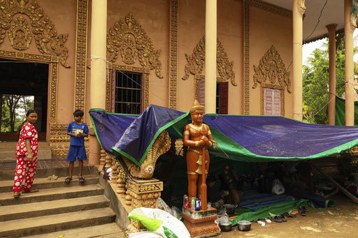 Peoples who are displaced by the conflict between Thailand and Cambodia stand near their makeshift tent at a resettlement camp in Siem Reap