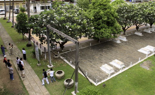 FILE - Tourists take their tour at the grave side in the former Pol Pot 's notorious S-21 prison