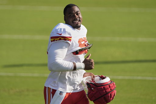 Kansas City Chiefs defensive tackle Chris Jones acknowledges fans as he jogs between drills during Back Together Weekend at the team's NFL football training camp