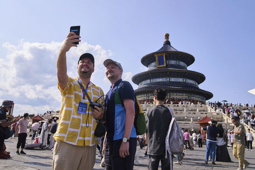 Tourists take a selfie at the Temple of Heaven as they take a half-day tour offering by a travel agency Trip.com Group