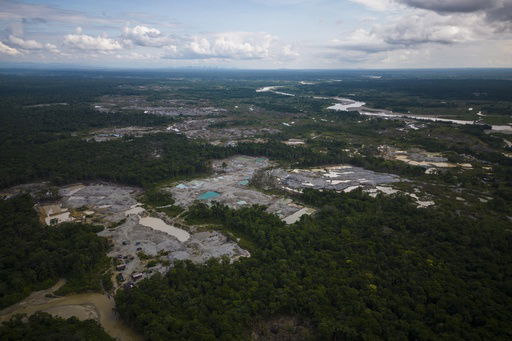 FILE - Visible deforestation from illegal mining surrounds the Quito River