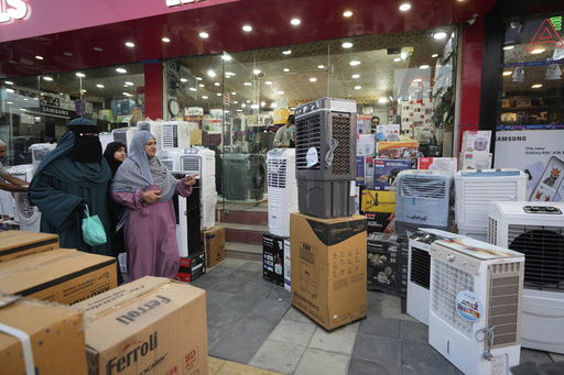 FILE - People purchase air conditioners at a shop on a hot summer day in Srinagar