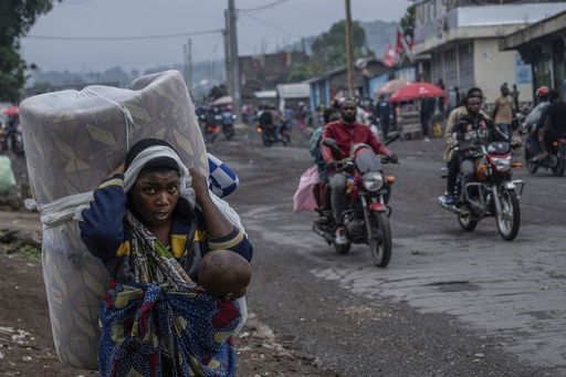 FILE - People displaced by the fighting with M23 rebels make their way to the center of Goma