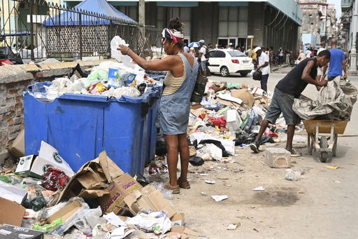 A woman searches through a dumpster looking for useful items