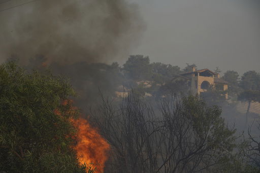 Flames burn near a house in Souni village