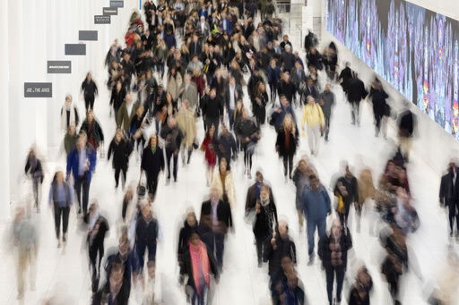 FILE - Commuters walk along a corridor in the World Trade Center