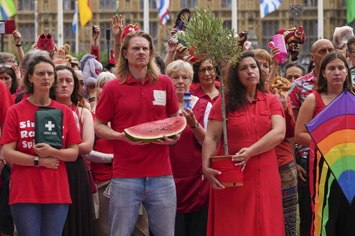 Members of the public wearing red demonstrate outside Parliament to protest the treatment of people in Gaza on the final day before summer recess at Parliament Square in London