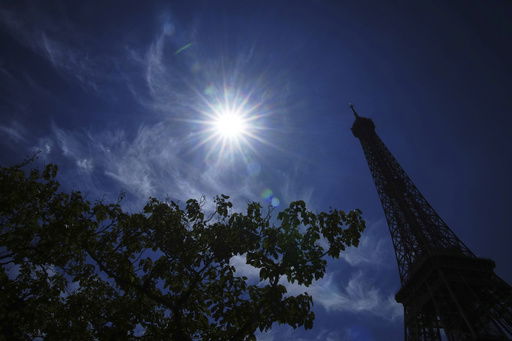 The sun shines over the the Eiffel Tower during a heat wave