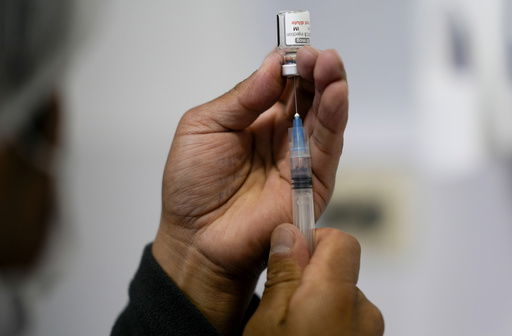 FILE - A healthcare worker prepares a shot of the Pfizer COVID-19 vaccine in La Paz