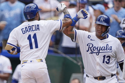 Kansas City Royals' Maikel Garcia (11) celebrates with Salvador Perez (13) after hitting a two-run home run during the fourth inning in the first baseball game of a doubleheader against the Cleveland Guardians