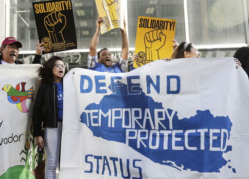 FILE - Supporters of temporary protected status immigrants hold signs and cheer at a rally before a conference announcing a lawsuit against the Trump administration over its decision to end a program letting immigrants live and work legally in the United States outside of a federal courthouse in San Francisco