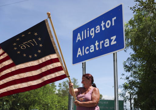 Rana Mourer waves an American flag outside of the migrant detention facility dubbed