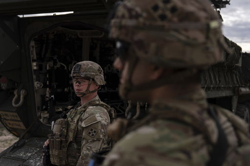 U.S Army Sgt. Brenden Richards monitors the area while standing next to a Stryker combat vehicle Wednesday