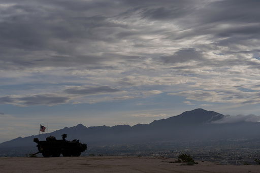A Stryker combat vehicle sits atop a hill overlooking the U.S.-Mexico border fence in Sunland Park