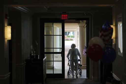 A woman uses a walker as she exits an assisted living building at the Toby and Leon Cooperman Sinai Residences