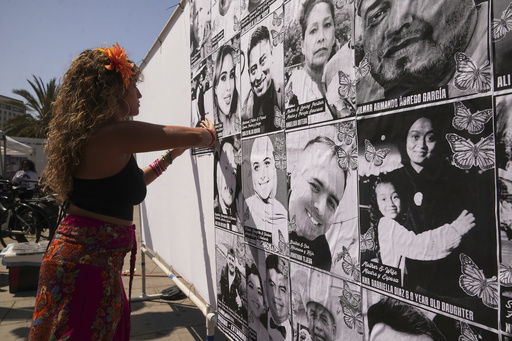 Special needs teacher Deja Nebula sets up an art installation displaying names and faces of people who have been detained