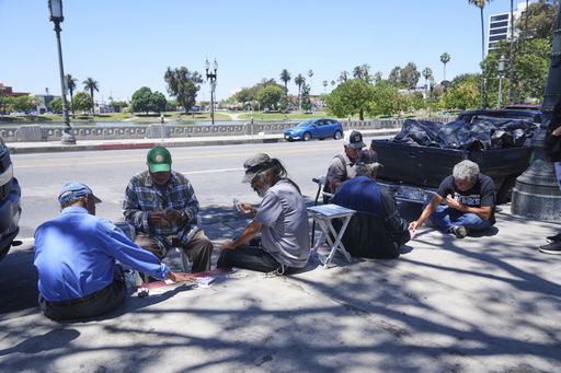 People play cards on a sidewalk at MacArthur Park