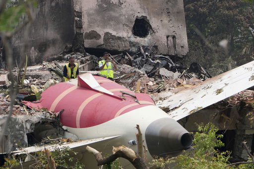 Officials inspect the site of Thursday's Air India plane crash on the roof of a building in Ahmedabad