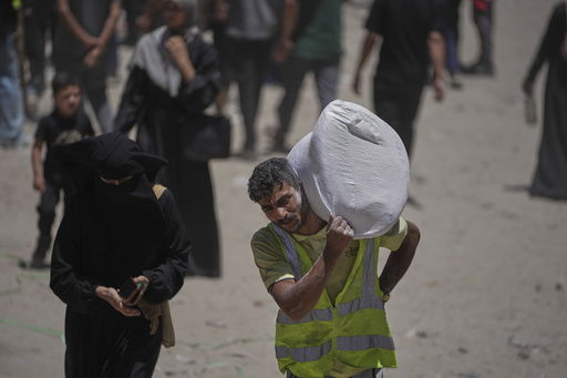 Palestinians carry bags of flour distributed by the World Food Programme (WFP) in Gaza City