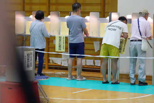 Voters fill in their ballots in the upper house election at a polling station Sunday