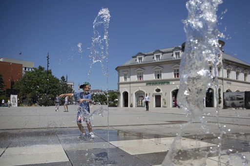 A boy plays in a fountain during hot weather in Kosovo's capital Pristina on Thursday