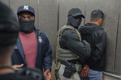 FILE - Immigration and Customs Enforcement agents escort a detained immigrant into an elevator after he exited an immigration courtroom