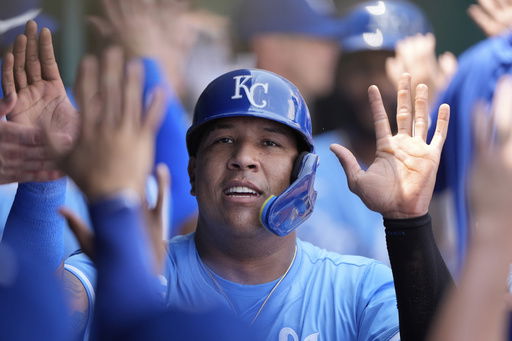 Kansas City Royals' Salvador Perez celebrates in the dugout after scoring on a two-run double hit by Kansas City Royals' John Rave during the second inning of a baseball game against the New York Mets