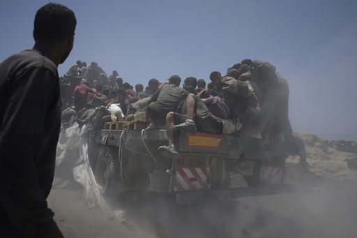 FILE - Palestinians hold onto an aid truck returning to Gaza City from the northern Gaza Strip on Tuesday